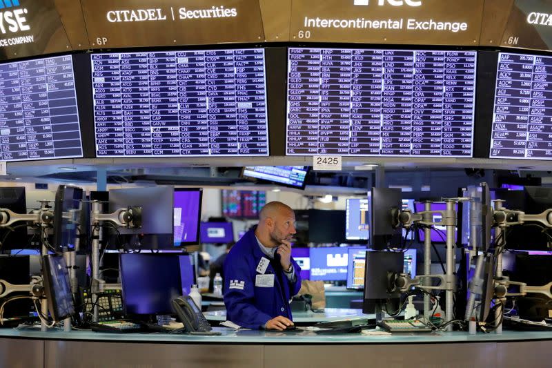 FILE PHOTO: FILE PHOTO: A trader works on the trading floor at the New York Stock Exchange (NYSE) in Manhattan, New York City