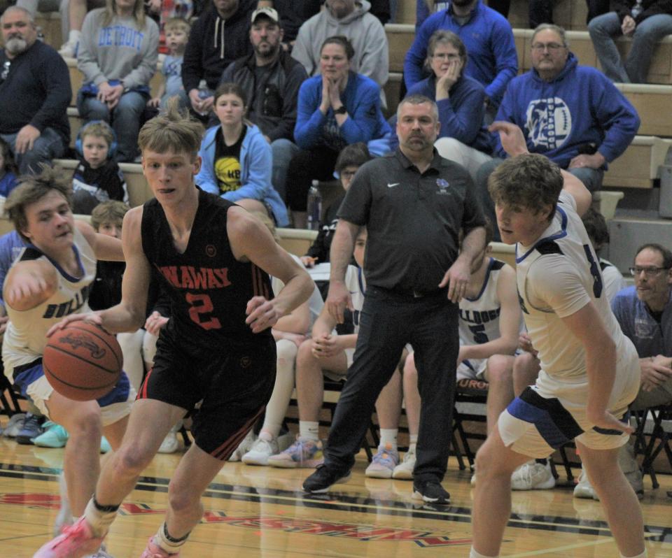 Onaway senior guard Jadin Mix (2) drives past Inland Lakes' Aidan Fenstermaker (left) and Connor Wallace (right) during the first half on Friday.