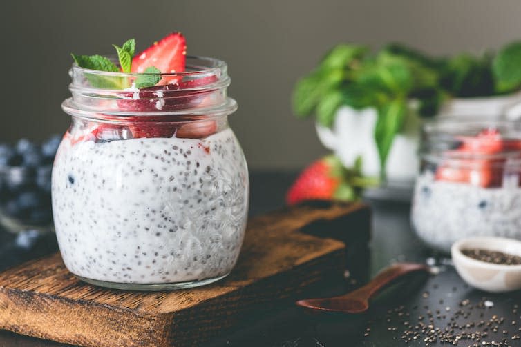 Glass jar filled with pudding and topped with fruit.