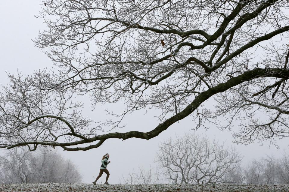 Lauren Clemens runs through a misty snow covered landscape in the Meadow at Nellies Cave Park in Blacksburg, Va. Monday, Dec. 7 2020. 