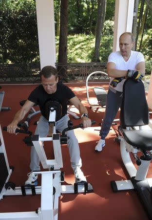 Russian President Vladimir Putin (R) and Prime Minister Dmitry Medvedev exercise in a gym at the Bocharov Ruchei state residence in Sochi, Russia, August 30, 2015. REUTERS/Michael Klimentyev/RIA Novosti/Kremlin