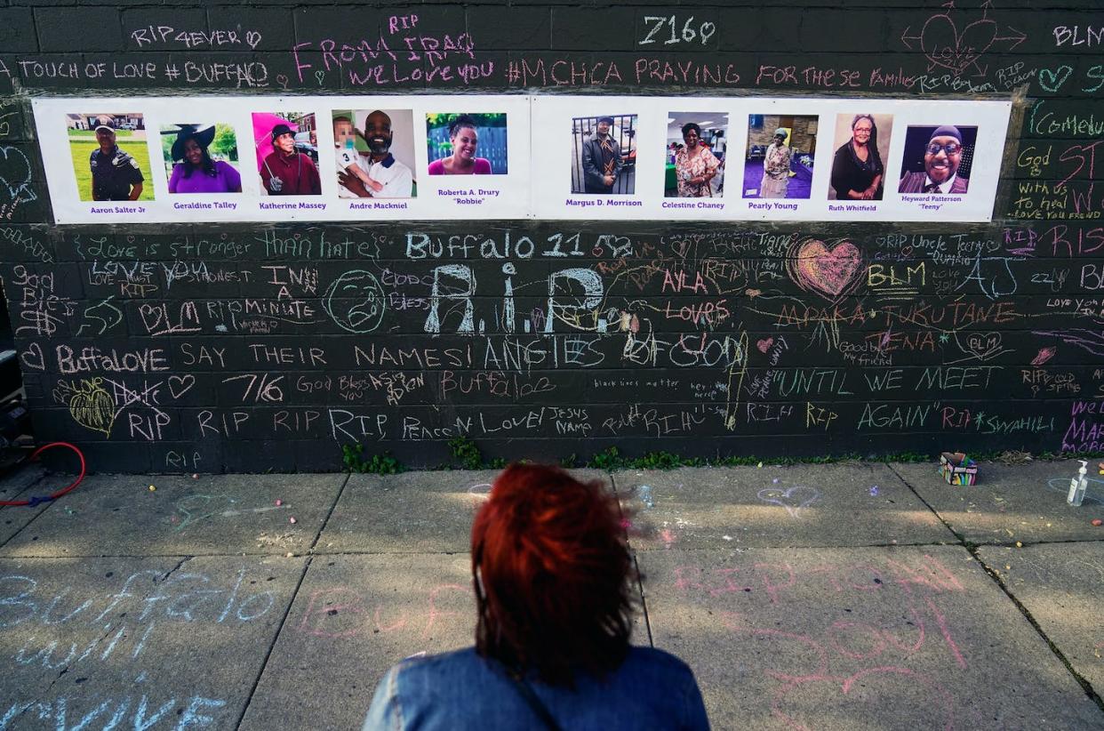 A person visits a makeshift memorial near the scene of the fatal shooting at a supermarket in Buffalo, New York, on May 19, 2022. <a href="https://newsroom.ap.org/detail/RacialInjusticeMentalToll/1132399bfef84f2fa1ec2f392e854919/photo?Query=buffalo&mediaType=photo&sortBy=arrivaldatetime:desc&dateRange=Anytime&totalCount=129846&currentItemNo=19" rel="nofollow noopener" target="_blank" data-ylk="slk:AP Photo/Matt Rourke;elm:context_link;itc:0;sec:content-canvas" class="link ">AP Photo/Matt Rourke</a>