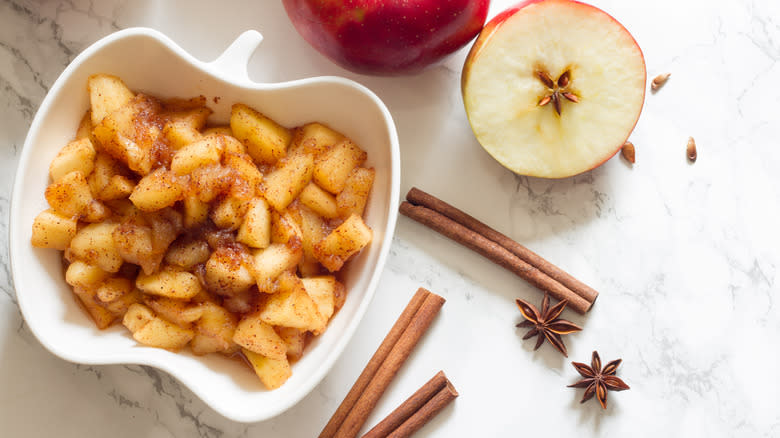 Apple pie filling in a bowl topped with cinnamon