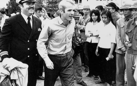 US Navy Lt. Cmdr. John McCain is escorted by Lt. Cmdr. Jay Coupe Jr., to Hanoi's Gia Lam Airport, after McCain was released from captivity in a Vietnamese prisoner of war camp - Credit:  Horst Faas/AP