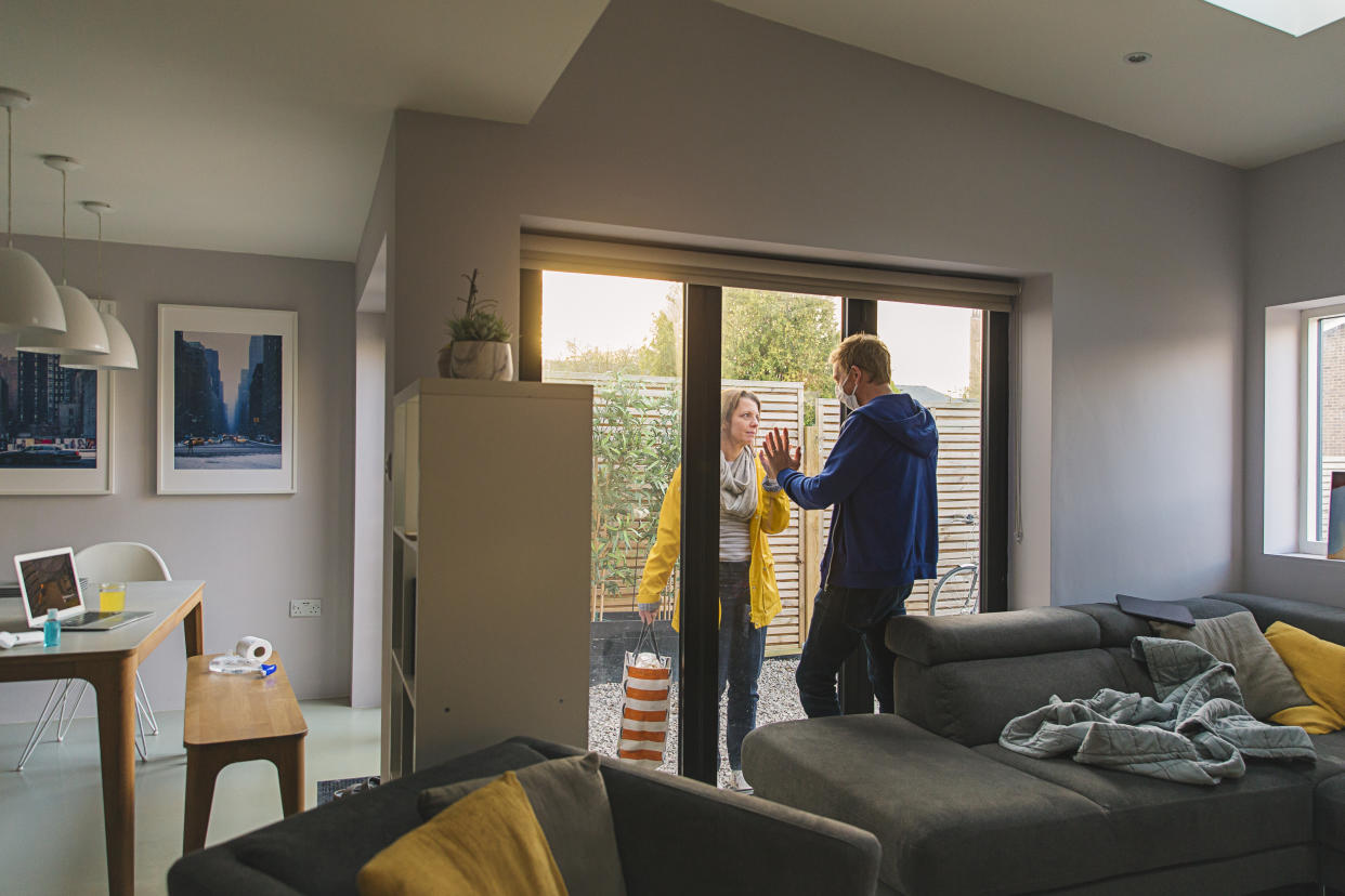 Woman delivering items to her husband who is in self isolation at home