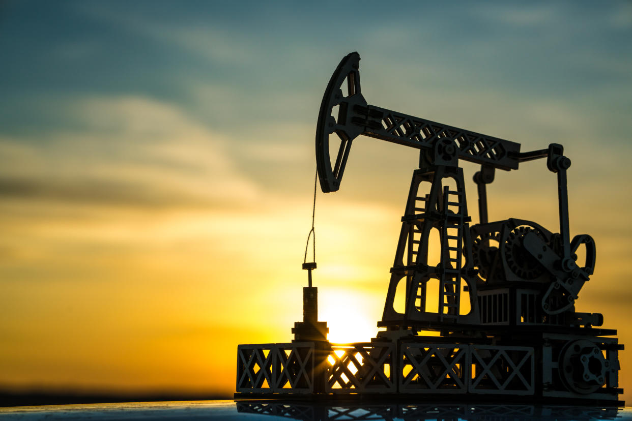 Oil pump on a sunset background. Oil production, fuel, natural resources.