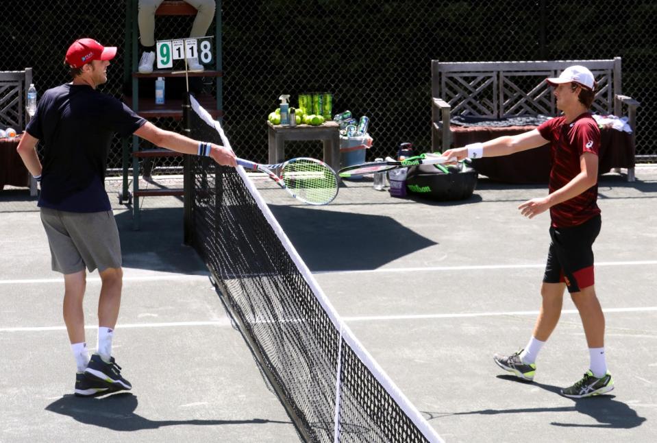 Sam Querrey, left, and Brandon Holt touch rackets instead of shaking hands.
