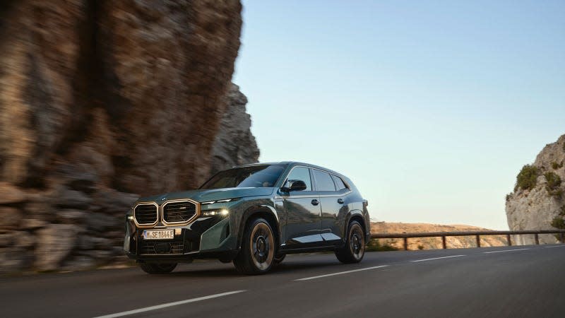 A photo of the BMW XM SUV driving on a mountain road. 