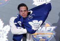 Jun 24, 2016; Buffalo, NY, USA; Auston Matthews puts on a team jersey after being selected as the number one overall draft pick by the Toronto Maple Leafs in the first round of the 2016 NHL Draft at the First Niagra Center. Mandatory Credit: Timothy T. Ludwig-USA TODAY Sports