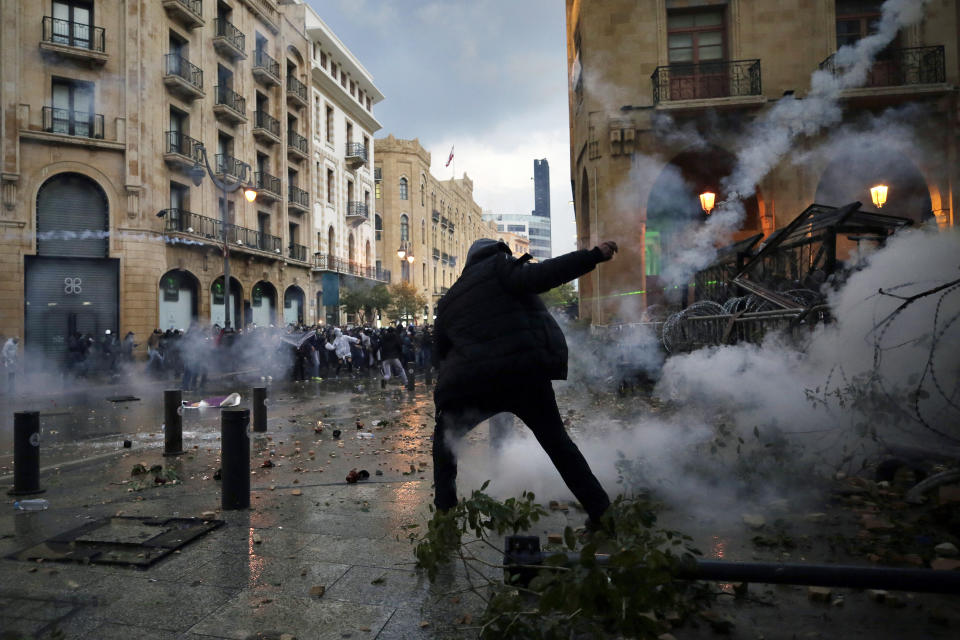 Anti-government protesters clash with the riot police, during a protest at a road leading to the parliament building in Beirut, Lebanon, Saturday, Jan. 18, 2020. Riot police fired tears gas and sprayed protesters with water cannons near parliament building to disperse thousands of people after riots broke out during a march against the ruling elite amid a severe economic crisis. (AP Photo/Hassan Ammar)