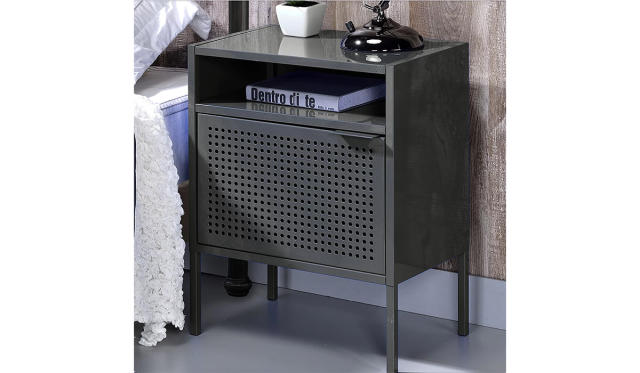 Charcoal metal perforated nightstand next to a bed