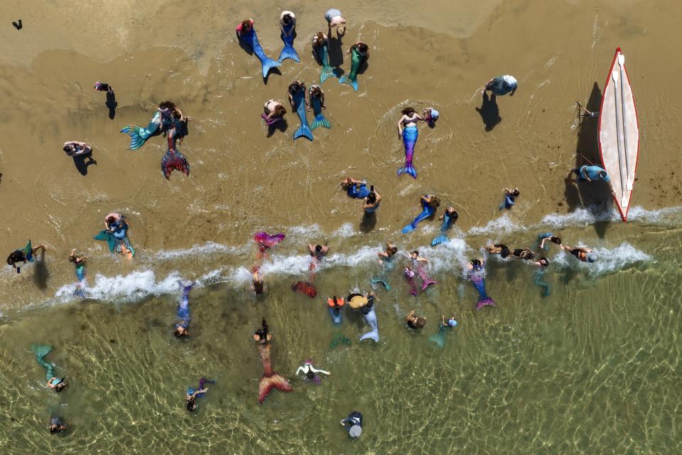 Members of the Israeli Mermaids Community swim with their mermaid tails at the Mediterranean Sea in Bat Yam, near Tel Aviv, Israel, Friday, July 21, 2023. (AP Photo/Oded Balilty)