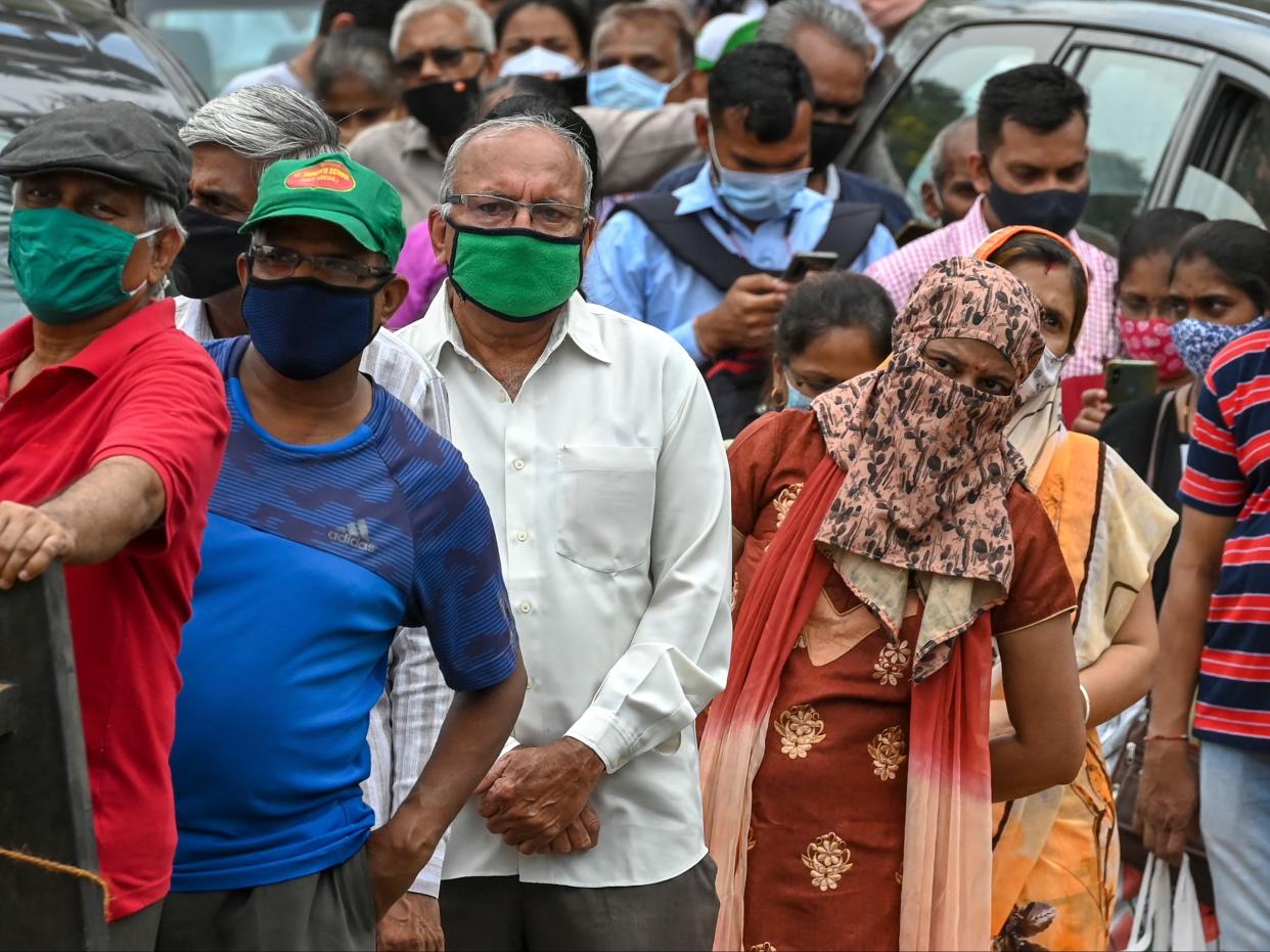 People wait in a queue to receive the Covid-19 coronavirus vaccine at a vaccination centre in Mumbai (PUNIT PARANJPE/AFP via Getty Images)