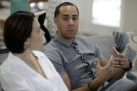 NBA referees Jonathan Sterling, right, gestures as he sits with his wife Lauren Holtkamp-Sterling, the only married couple in NBA refereeing history, during an interview at their home Thursday, Oct. 3, 2019 in Tampa, Fla. (AP Photo/Chris O'Meara)