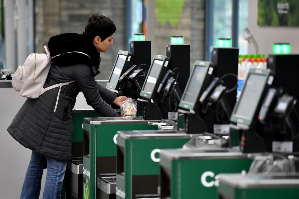 A row of self-service checkouts can be seen at a Woolworths store. 