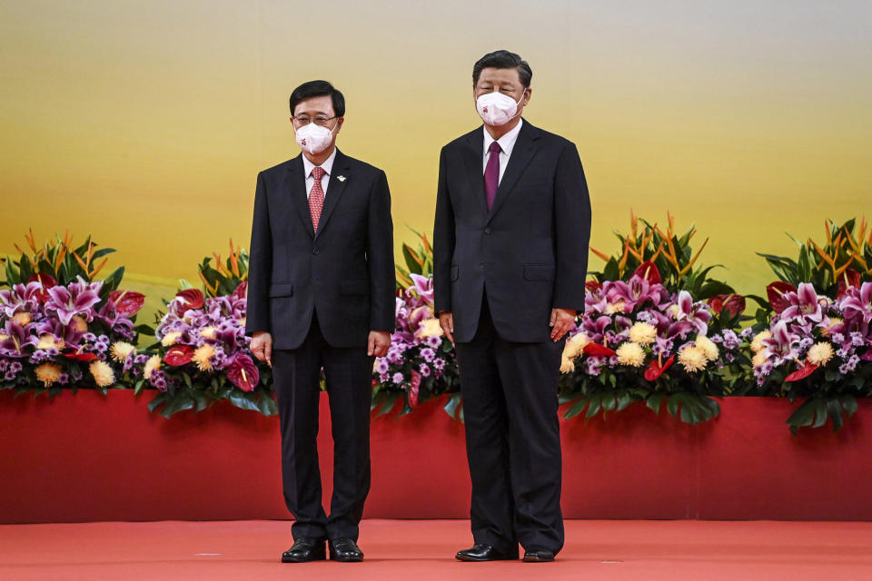 China's President Xi Jinping, right, stands with Hong Kong's new Chief Executive John Lee after Lee was sworn in as the city's new leader, during a ceremony to inaugurate the city's new government in Hong Kong on July 1, 2022, on the 25th anniversary of the city's handover from Britain to China. (Selim Chtayti / Pool via AP)