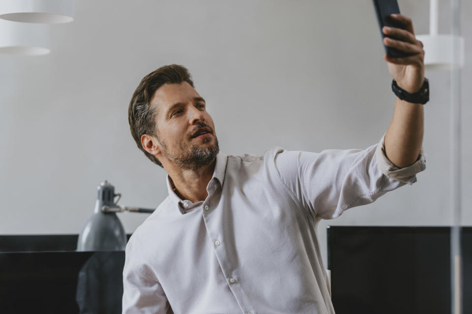 businessman taking a selfie in his office