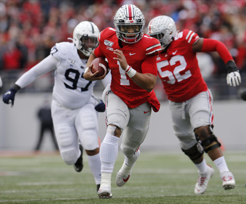 Ohio State quarterback Justin Fields, center, runs for a first down against Penn State during the first half of an NCAA college football game Saturday, Nov. 23, 2019, in Columbus, Ohio. (AP Photo/Jay LaPrete)