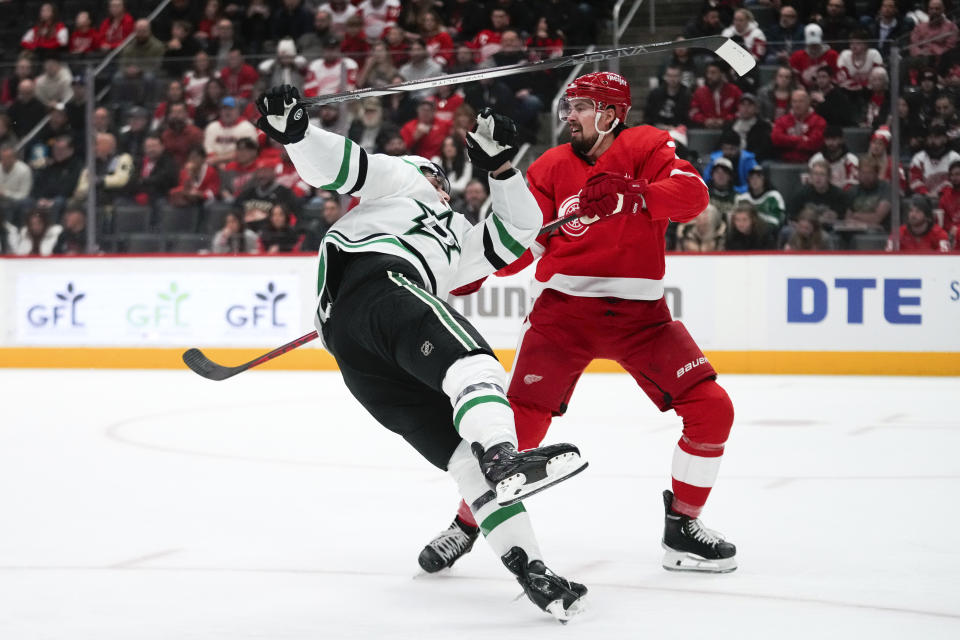 Dallas Stars left wing Mason Marchment (27) is checked by Detroit Red Wings defenseman Justin Holl (3) in the first period of an NHL hockey game Tuesday, Jan. 23, 2024, in Detroit. (AP Photo/Paul Sancya)