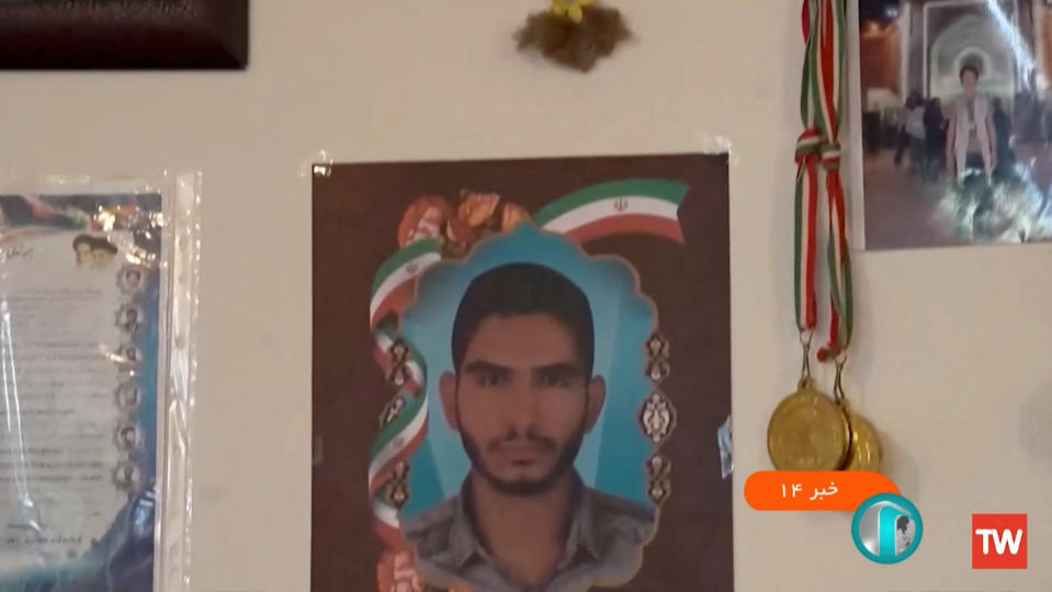 A picture of Ruhollah Ajamian is seen on a wall as Seyyed Mohammad Hosseini and Mohammad-Mehdi Karami are executed by hanging for allegedly killing Ajamian, a member of the security forces during nationwide protests that followed the death of 22-year-old Kurdish Iranian woman Mahsa Amini, in an unknown location in Iran in this undated still image obtained from a video by WANA (West Asia News Agency)/Handout via REUTERS   ATTENTION EDITORS - THIS PICTURE WAS PROVIDED BY A THIRD PARTY