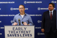 Micha Siegel, left, of Boca Raton, Fla., speaks at a news conference about his experience having been treated with monoclonal antibodies after a bout with COVID-19, as Florida Gov. Ron DeSantis, right, listens, Thursday, Sept. 16, 2021, at the Broward Health Medical Center in Fort Lauderdale, Fla. DeSantis was there to promote the use of monoclonal antibody treatments for those infected with COVID-19. (AP Photo/Wilfredo Lee)