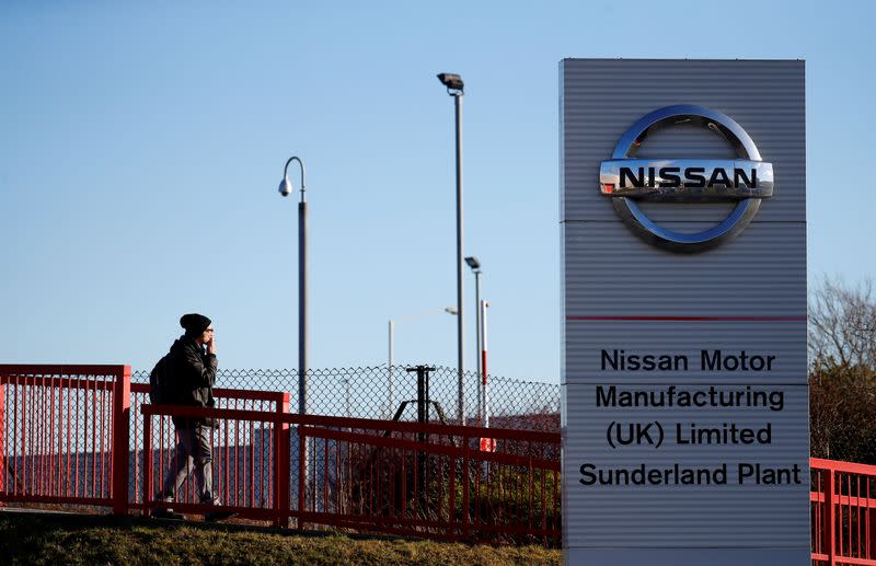 FILE PHOTO: A man walks past a sign at the Nissan car plant in Sunderland