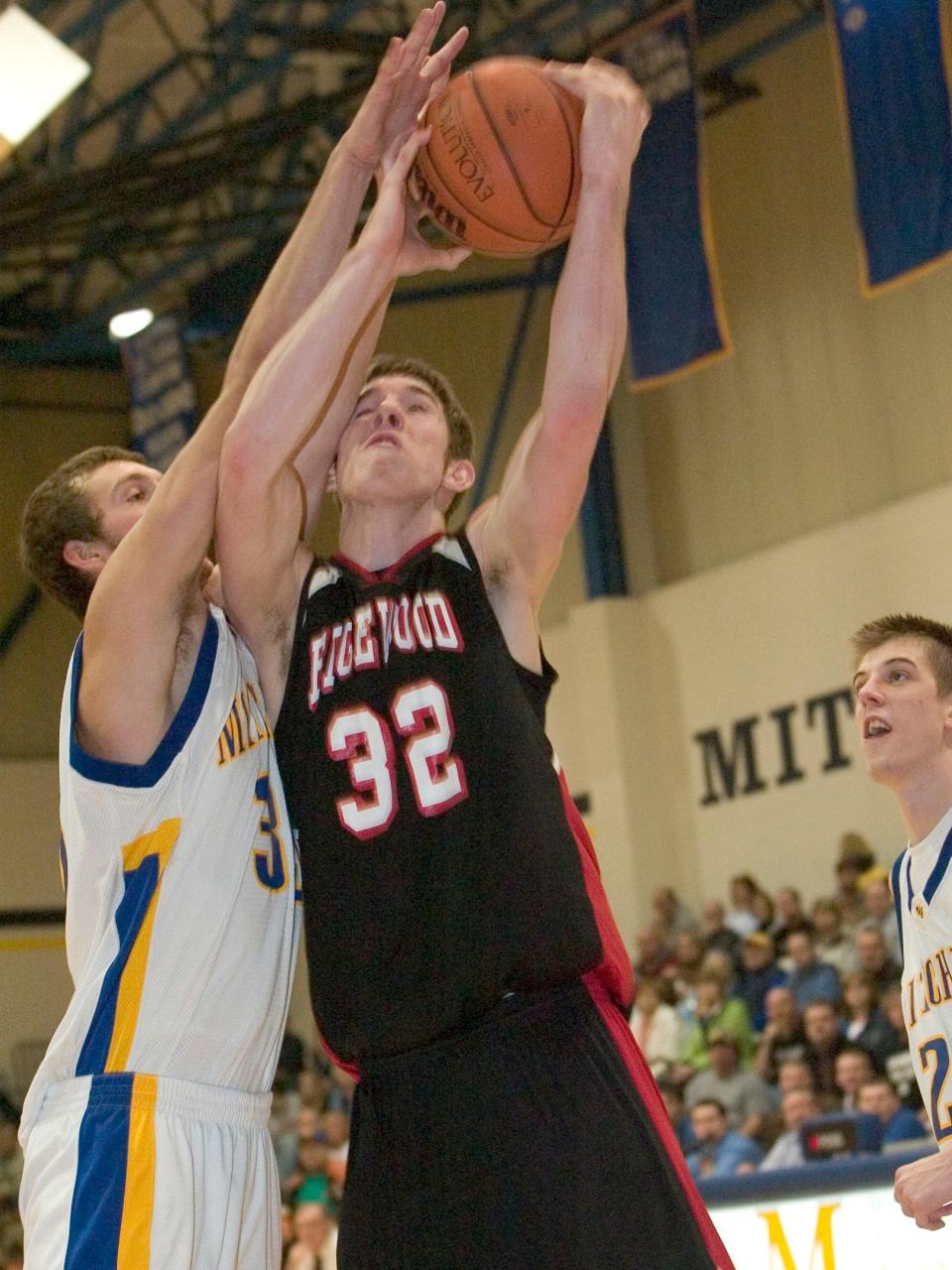 Garrett Butcher absorbs a foul from Zach Kern during the second half of Edgewood's matchup with Mitchell in 2007.