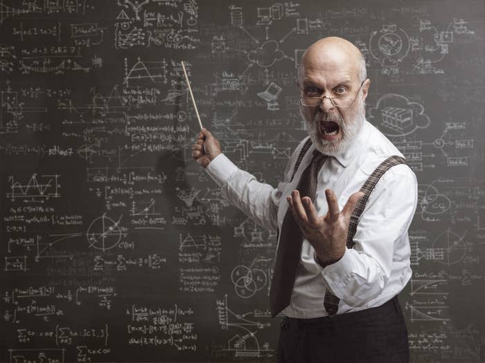 A teacher looking angry in front of the chalkboard