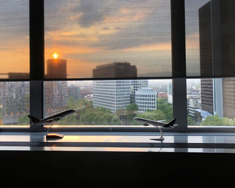 The sun sets behind an office window with models of Lufthansa and Qatar Airways planes, in Frankfurt