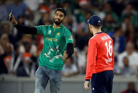 Britain Cricket - England v Pakistan - NatWest International T20 - Emirates Old Trafford - 7/9/16 A Pakistan fan invades the pitch as England's Eoin Morgan looks on Action Images via Reuters / Lee Smith Livepic