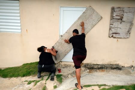 Couple boards up the door of their beachfront house as Tropical Storm Dorian approaches in Yabucoa