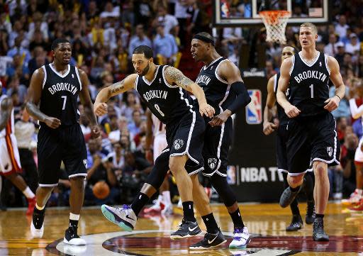 Deron Williams (8) y Paul Pierce (34) de los Brooklyn Nets celebran durante el partido que vencieron 96-95 al Miami Heat el 12 de marzo de 2014 en el American Airlines Arena de Miami (GETTY IMAGES NORTH AMERICA/AFP | Mike Ehrmann)