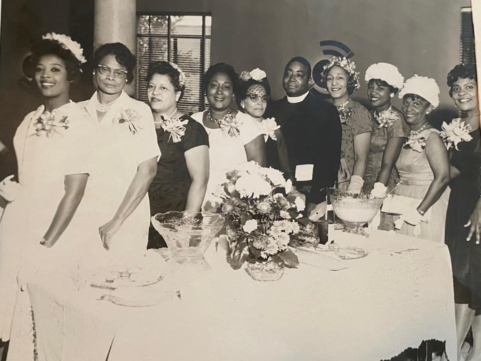 people pose and smile wearing fancy clothes in an old family photo