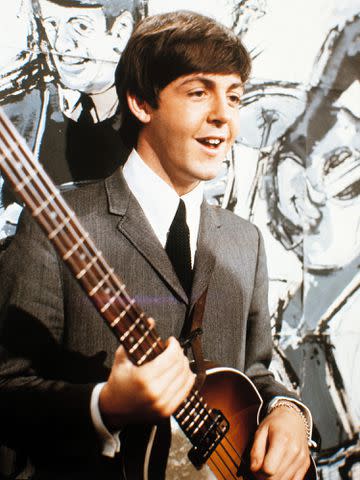 <p>kpa/United Archives/Getty </p> A 1962 photograph of Paul McCartney holding a guitar