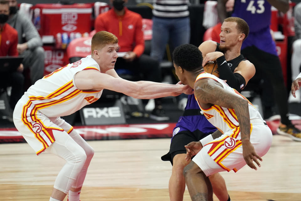 Toronto Raptors guard Malachi Flynn (8) grabs the ball away from Atlanta Hawks guard Kevin Huerter (3) and guard Brandon Goodwin (0) during the second half of an NBA basketball game Tuesday, April 13, 2021, in Tampa, Fla. (AP Photo/Chris O'Meara)