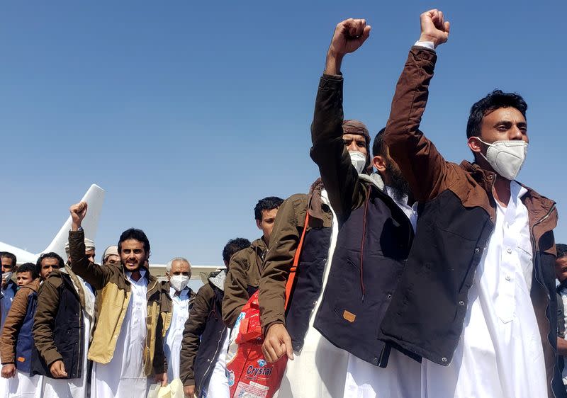 Freed Saudi-led coalition prisoners shout slogans as they arrive, after release in a prisoner swap, at Sayoun airport