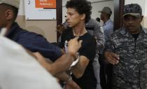 In this June 13, 2019 file photo Rolfy Ferreyra Cruz, center, is taken to court by police in Santo Domingo, Dominican Republic. The suspect in the shooting of former baseball star David Ortiz has been charged with drug and firearm possession in New Jersey. The U.S. attorney's office in Newark announced the indictment Thursday, June 20, 2019 for Rolfy Ferreyra Cruz. (AP Photo/Roberto Guzman, file)
