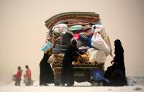 Displaced Syrians who fled Raqa city are seen during a sandstorm in Ain Issa on May 19, 2017