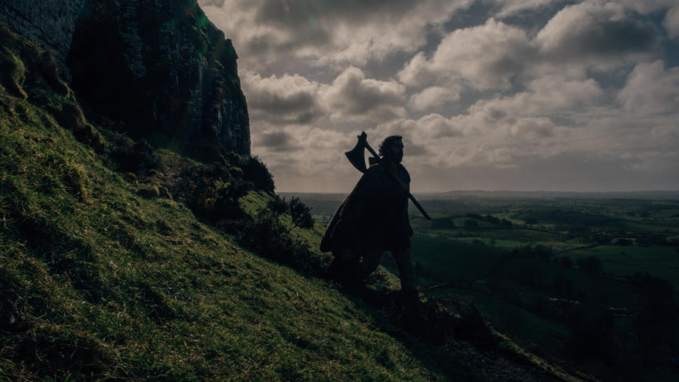 Dev Patel carrying an axe in The Green Knight