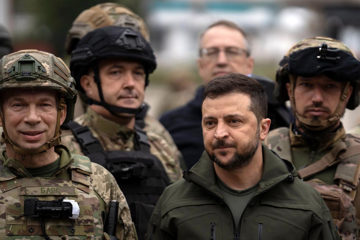 Ukrainian President Volodymyr Zelenskyy poses for a photo with soldiers after attending a national flag-raising ceremony in the freed Izium, Ukraine, Wednesday, Sept. 14, 2022. Zelenskyy visited the recently liberated city on Wednesday, greeting soldiers and thanking them for their efforts in retaking the area, as the Ukrainian flag was raised in front of the burned-out city hall building.