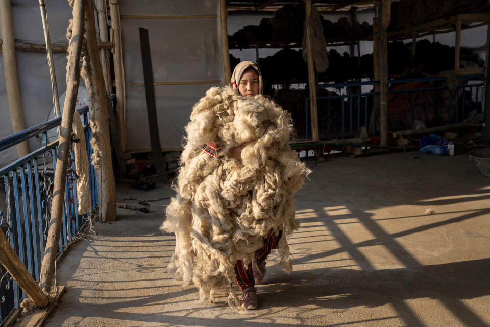An Afghan girl works at a traditional carpet factory in Kabul, Afghanistan, Sunday, March 5, 2023. After the Taliban came to power in Afghanistan, women have been deprived of many of their basic rights. (AP Photo/Ebrahim Noroozi)