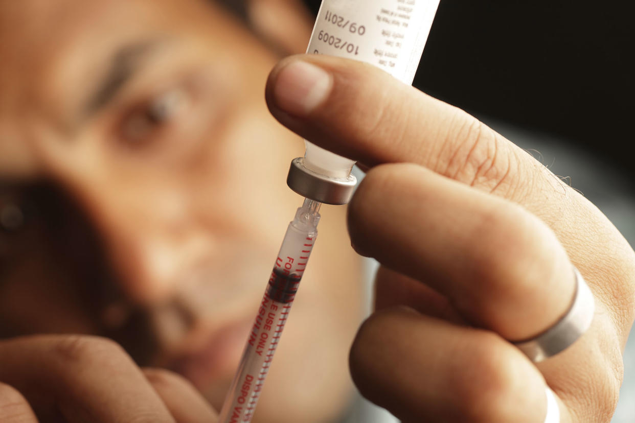 A male loading insulin into a needle