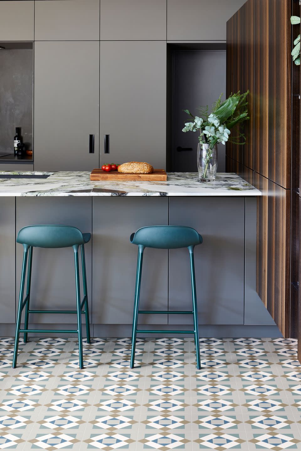 modern grey kitchen with ca pietra geometric patterned floor tiles teal bar stools and marble breakfast bar