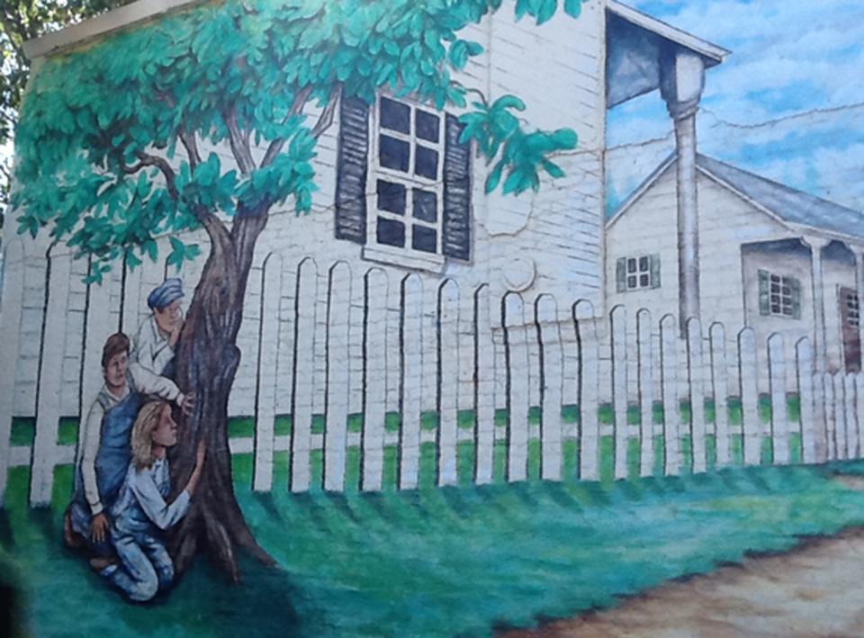 A hand-painted mural showing a scene of the 1960 bestseller " To Kill A Mockingbird" is shown on a building near where the homes of 1960's writers Harper Lee and Truman Capote's homes once stood in Monroeville, Alabama October 23, 2013. Lee, the 87-year-old author of the still-popular 1960 bestseller, recently filed a lawsuit against the museum dedicated to her novel in a dispute over a merchandising trademark. Photo taken October 23, 2013. REUTERS/Verna Gates (UNITED STATES - Tags: SOCIETY)