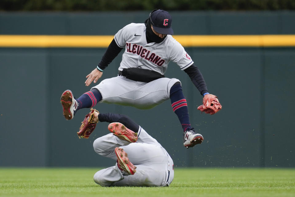 Cleveland Guardians second baseman Andres Gimenez, top, and falls over center fielder Myles Straw on a Detroit Tigers' Javier Baez fly ball in the fourth inning of the second game of a doubleheader baseball game in Detroit, Tuesday, April 18, 2023. (AP Photo/Paul Sancya)a