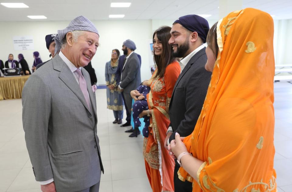 King Charles III smiles as he speaks to volunteers and learns about the programmes they deliver for the local community during a visit to the newly built Guru Nanak Gurdwara (Getty Images)