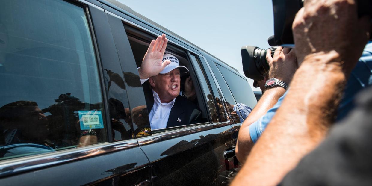 Republican Presidential candidate and business mogul Donald Trump talks to media from his car wearing a, "Make America Great Again," hat during his trip to the border on July 23, 2015 in Laredo, Texas.