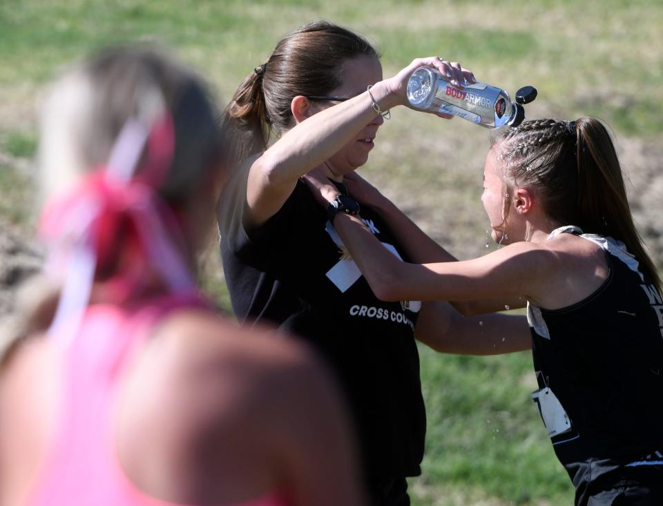Lubbock High's Reese Pena gets water poured on her head after the District 4-5A cross country meet, Thursday, Oct. 13, 2022, at Mae Simmons Park.