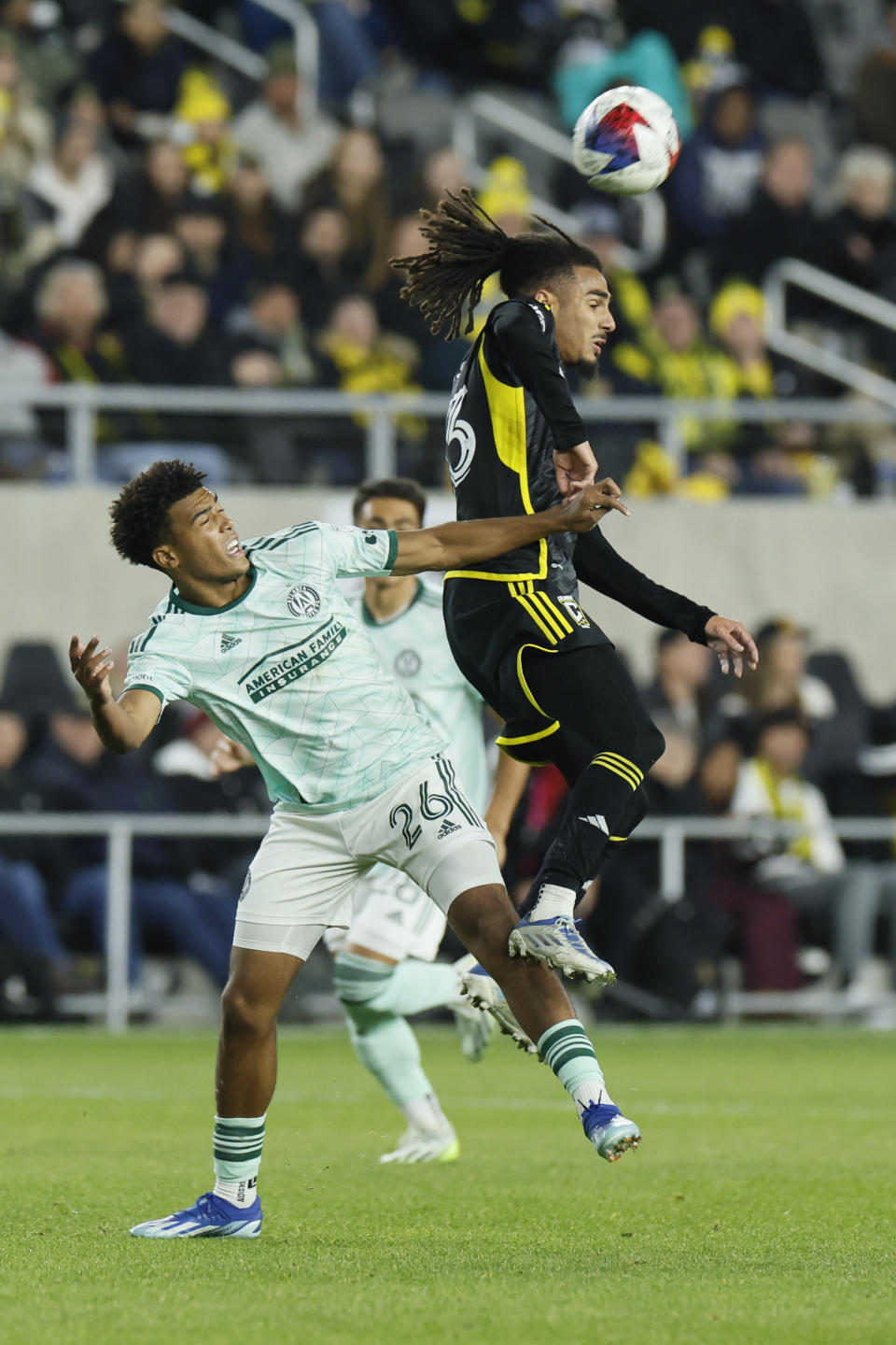 Columbus Crew's Mohamed Ramzdine Farsi, right, heads the ball away from Atlanta United's Caleb Wiley during the second half of an MLS playoff soccer match Sunday, Nov. 12, 2023, in Columbus, Ohio. (AP Photo/Jay LaPrete)