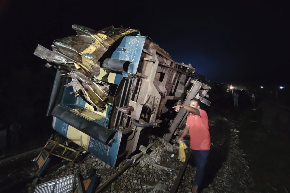 A local resident helps in a rescue work at the site where a cargo train has hit a passenger train, at Bhairab, Kishoreganj district, Bangladesh, Monday, Oct. 23, 2023, leaving more than dozen people dead and scores injured. (AP Photo/Mahmud Hossain Opu)